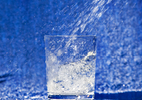 A glass with water splashing into it