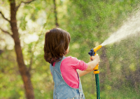 a little girl spraying a hose