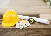 yellow hard hat, working gloves, tape measure, and plans