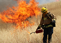 Fireman with flames behind him