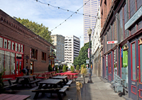 a down town area with string lights and lunch tables