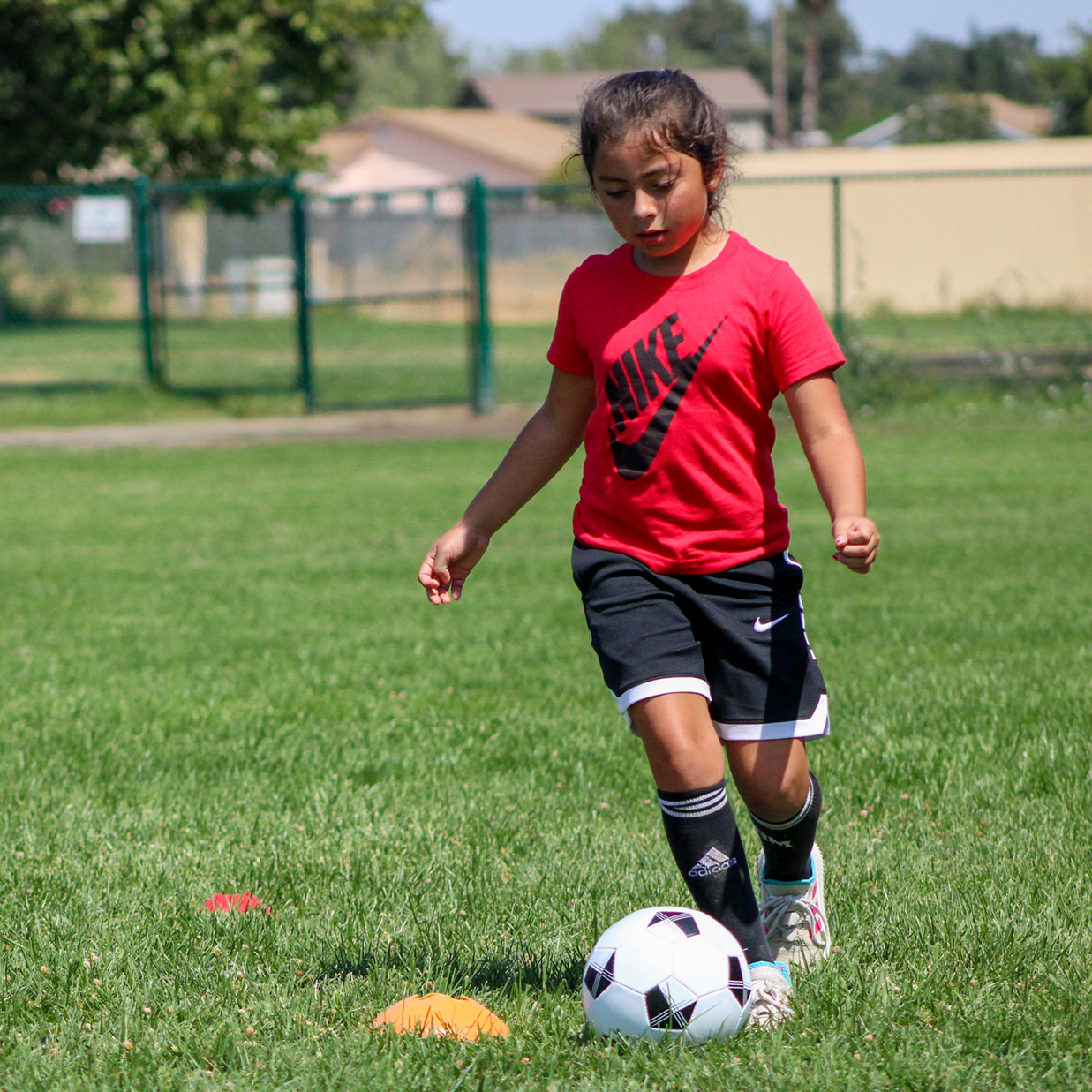 A young girl plays soccer on a field