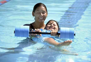 A child in a pool with a swim instructor.